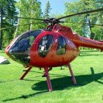 2002 MD 500N helicopter landed on green grass