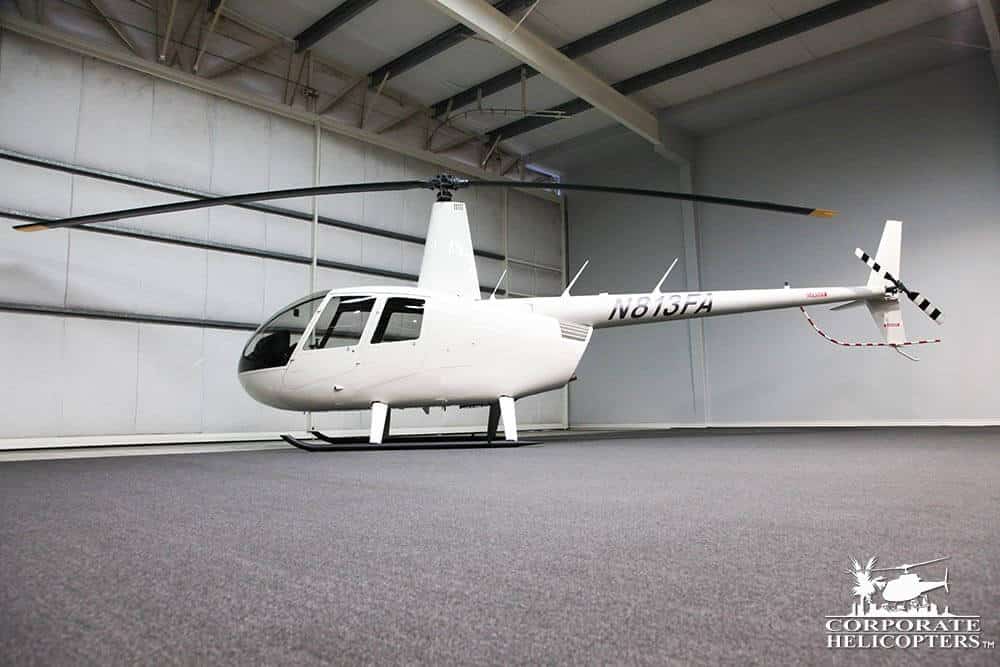 Side view of a 2019 Robinson R44 Raven I helicopter, parked in a hangar