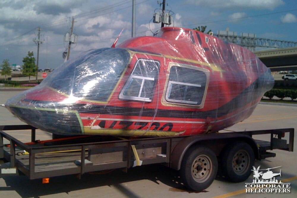 Bell 206B3 helicopter section wrapped in plastic on a trailer