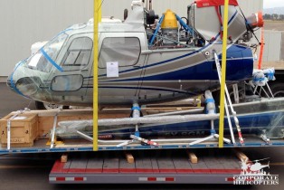 Side view: part of an AStar 350 B2 helicopter on a Pallet loading to flatbed trailer