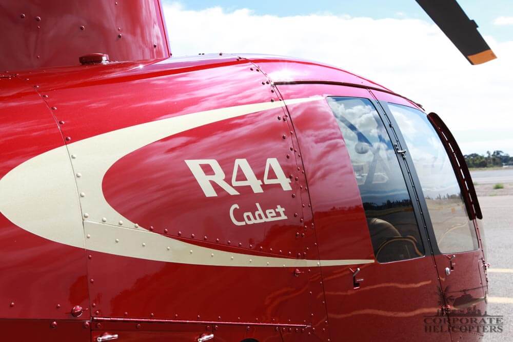 Closeup of R44 Cadet text on the side of a red helicopter