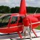 Man standing next to cherry red helicopter