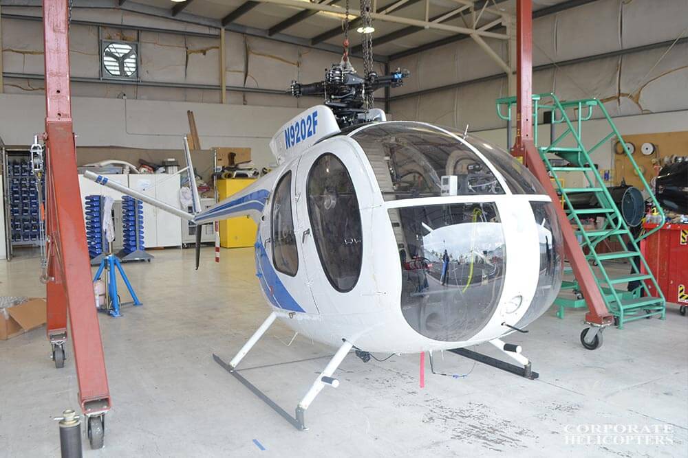 A MD500 helicopter being prepared for container shipping