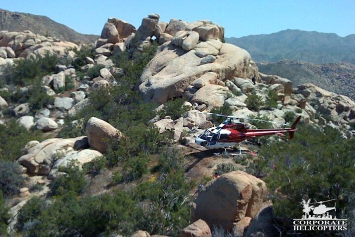 Helicopter landed on the side of a rocky Southern California mountain