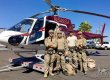 Helicopter Rappeling crew poses in front of helicopter