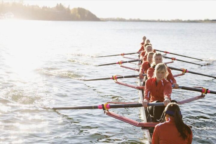 A female crew team of 9 rows across the water