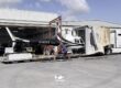 Helicopter being loaded into a custom shipping truck
