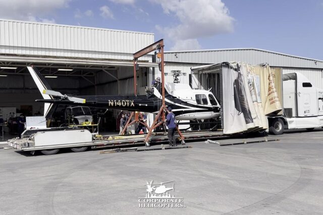 Helicopter being loaded into a custom shipping truck