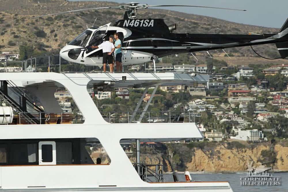 A helicopter landed on a yacht as people get out