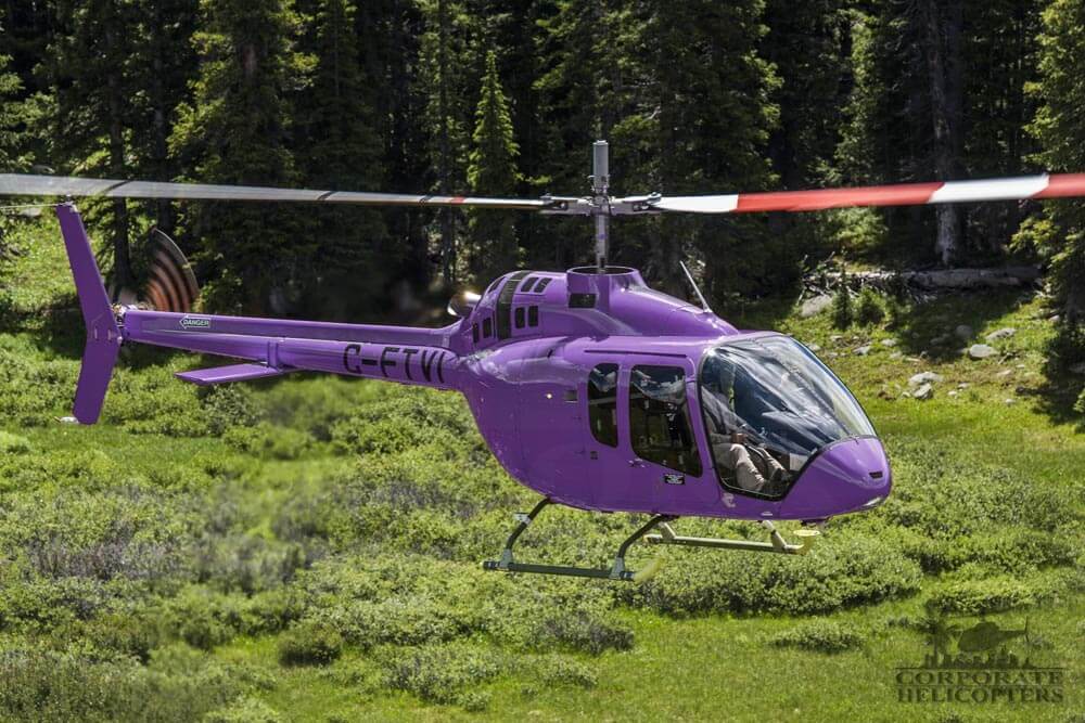 A pruple Bell 505 Jet Ranger X helicopter in flight