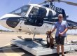 A man stands with Blade the dog in front of a helicopter