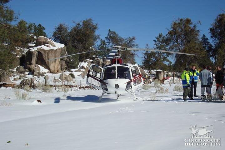 Helicopter in the snow, people next to it