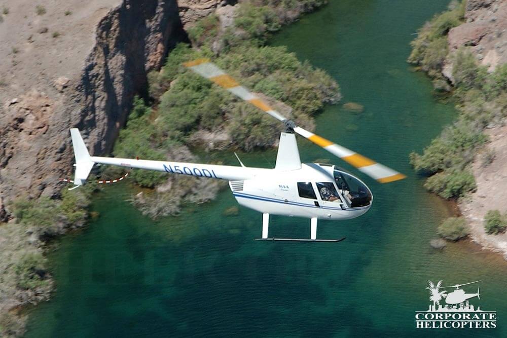 2002 Robinson R44 Raven I helicopter flying over a river