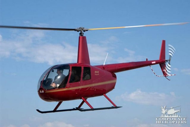 Red 2013 Robinson R44 Raven II helicopter in flight