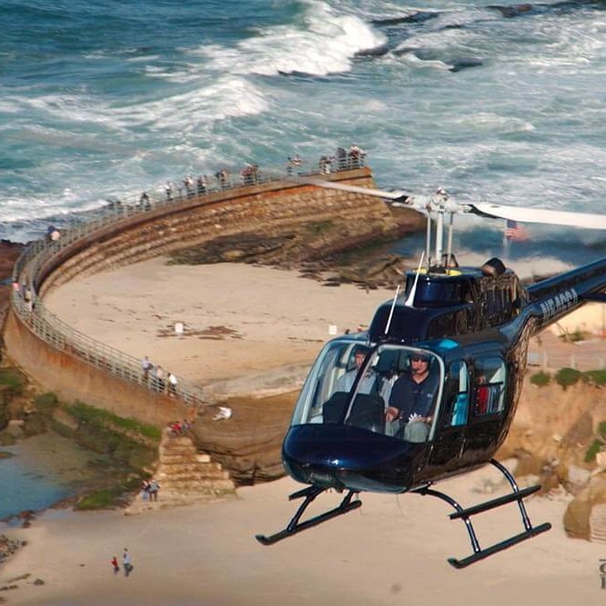A helicopter flies over the Children's Pool in La Jolla