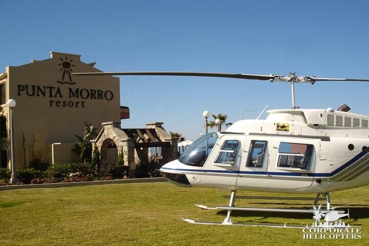 Helicopter landed on grass in front of Punta Morro Resort in Baja Mexico