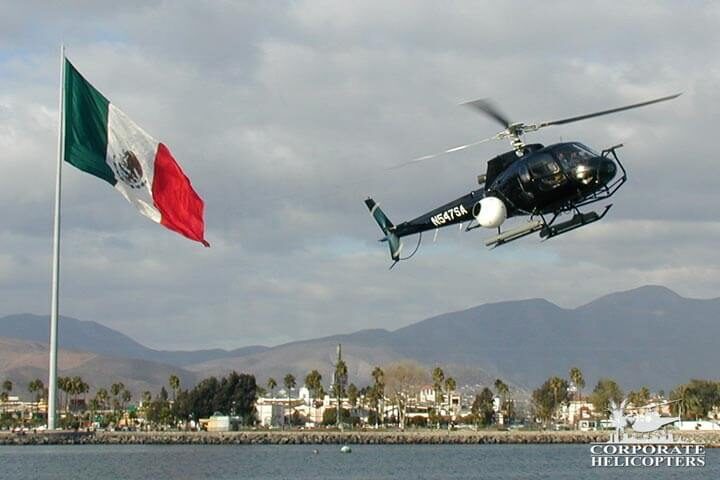 Aerial filming helicopter flies next to a large Mexican flag