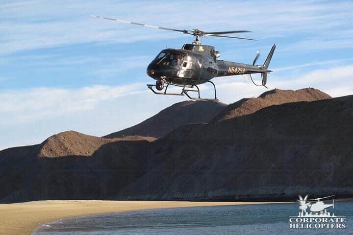 Helicopter flies just above coastline of Baja Mexico