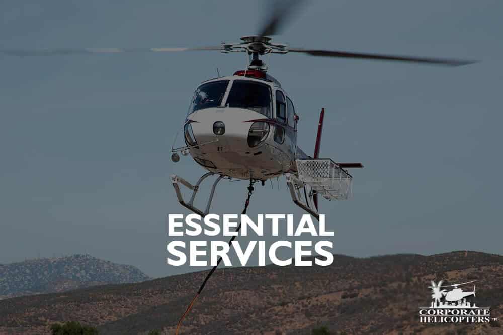 Helicopter with cargo basket and long line attached. Text overlay reads: Essential Services