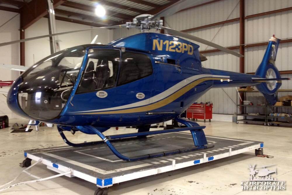 Side view of a 2001 EC 120 helicopter in a hangar