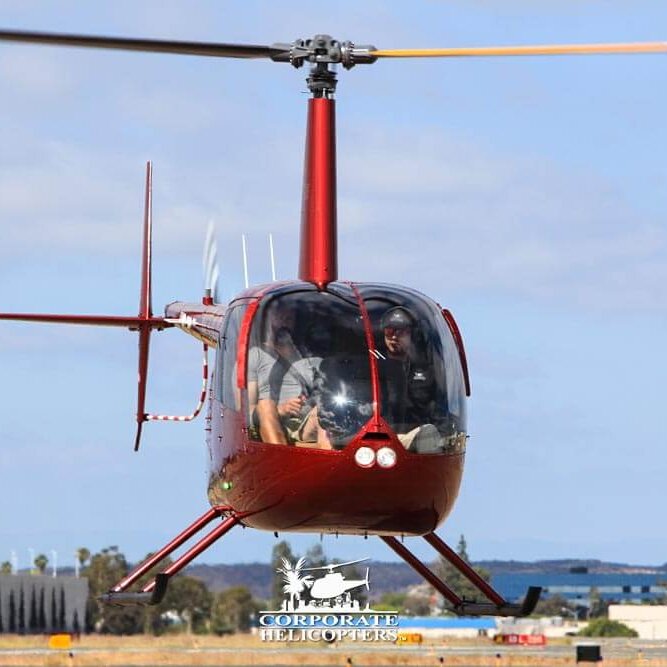 Robinson helicopter hovers over runway during flight training