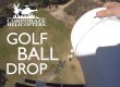 Golf balls being dropped into a field from a helicopter above. Text reads: Corporate Helicopters Golf ball drop