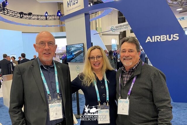 Ivor & Deann Shier pose for a photo with Tim Hutter in front of an Airbus display at the 2022 HAI Heli-Expo