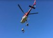 2 stuntmen rappel out of a helicopter in flight