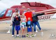 A 6-member family poses in front of a helicopter
