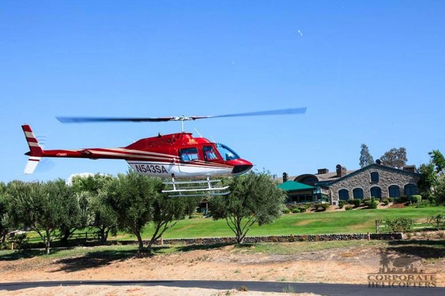 Helicopter hovers over a landing pad at a winery