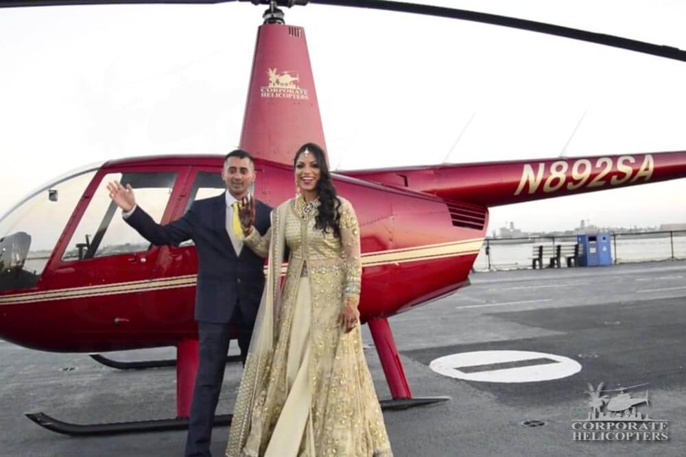 Groom and ornately-dressed bride in front of a helicopter on the USS Midway