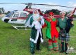 Irish Santa and 2 helpers stand in front of a helicopter