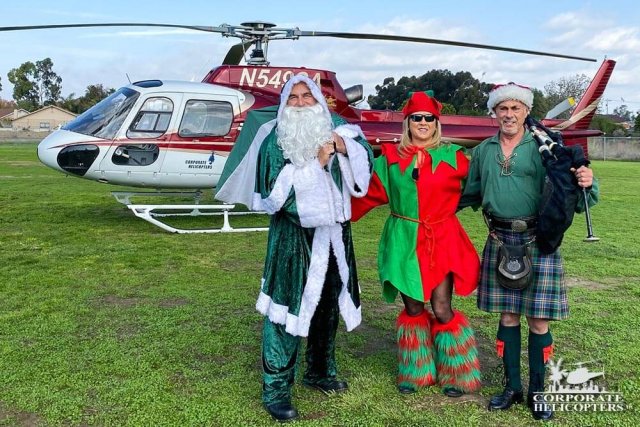 Irish Santa and 2 helpers stand in front of a helicopter