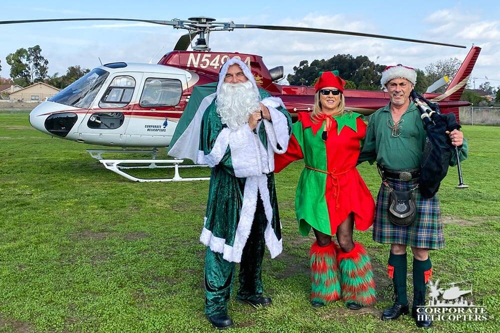 Irish Santa and 2 helpers stand in front of a helicopter