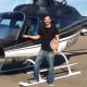 A flight student next to a helicopter