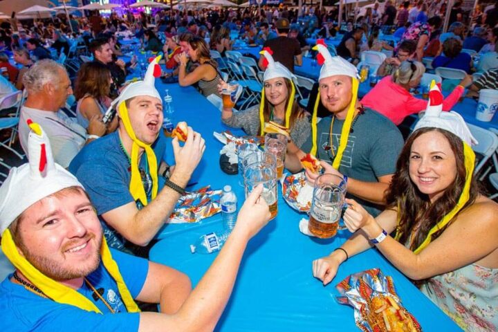 A group of people eat and raise beer steins at the La Mesa Oktoberfest