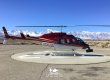 A LiDAR mapping helicopter landed in Bishop, California with snow-covered mountains in the background.