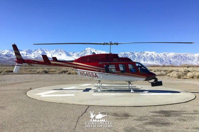 A LiDAR mapping helicopter landed in Bishop, California with snow-covered mountains in the background.