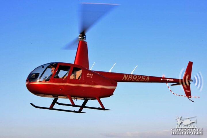 Red Robinson R44 helicopter in flight