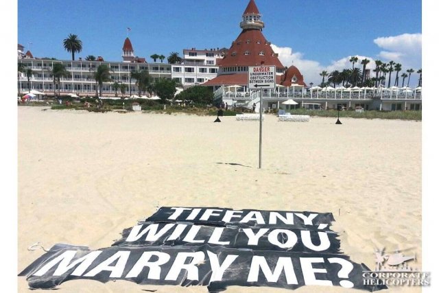 A sign in the sand in front of the Hotel Del Coronado reads: Tiffany Will You Marry Me?