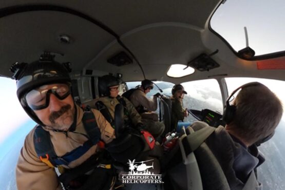 Skydivers prepare to jump out of a helicopter