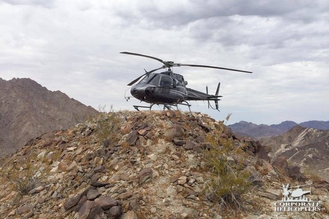 A helicopter landed on top of a rocky hill