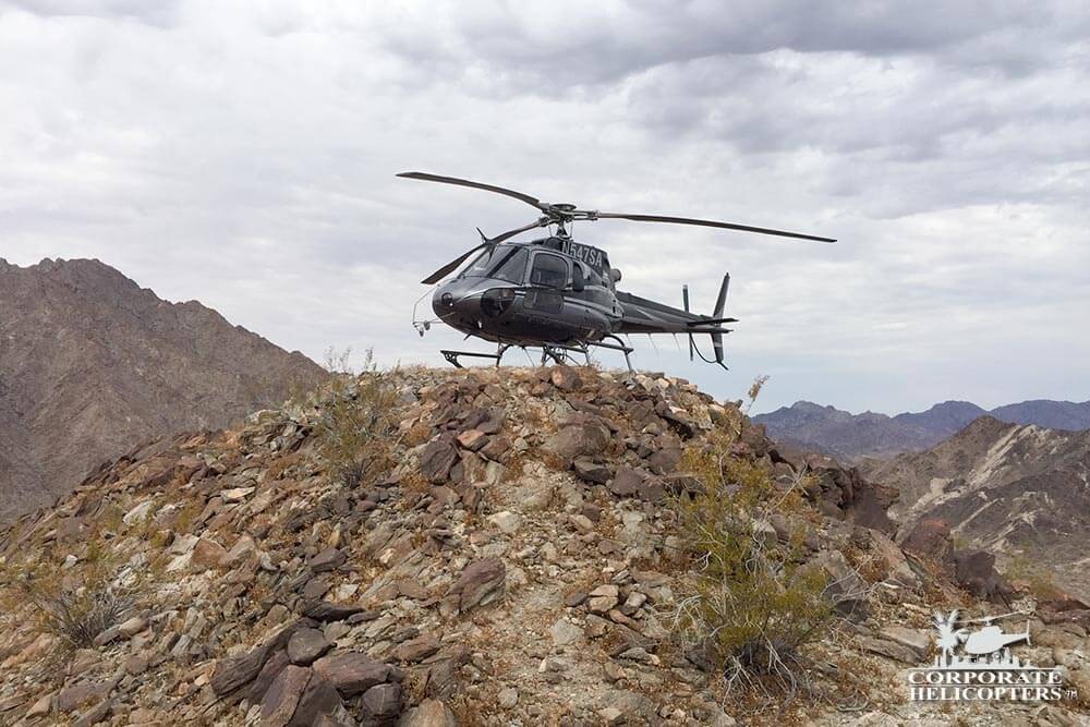 A helicopter landed on top of a rocky hill