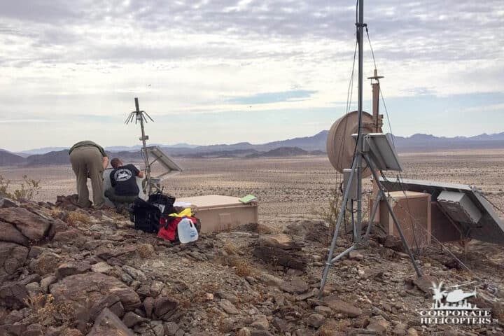 Satellite technology being worked on by a crew in a rocky desert