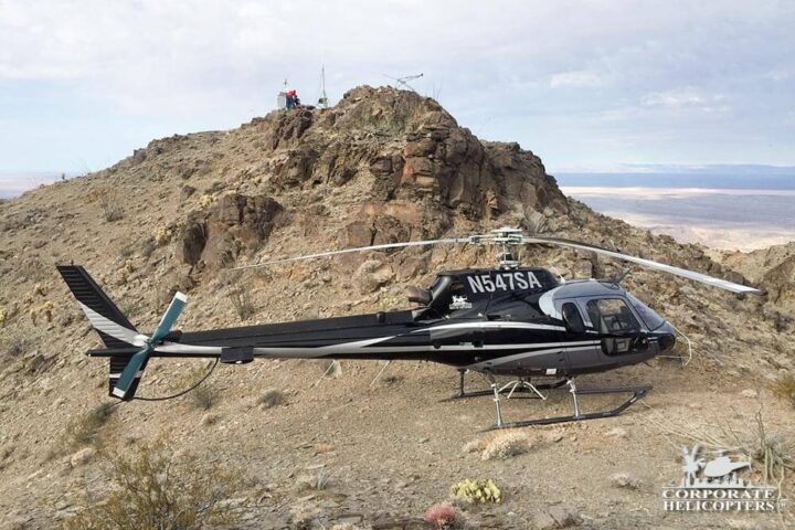 A helicopter landed on rocky desert terrain
