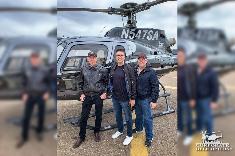 Ivor Shier stands with 2 other men in front of a helicopter