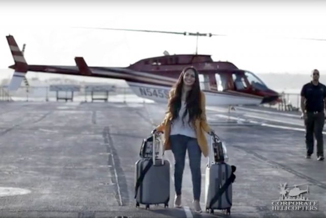 Woman with luggage prepares to board helicopter on the USS Midway aircraft carrier